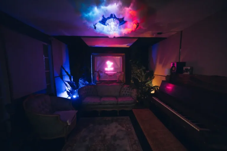 Lounge seating, upright piano and neon sign in the artist lounge at Ocean Blue Recording Studio in Decatur, GA